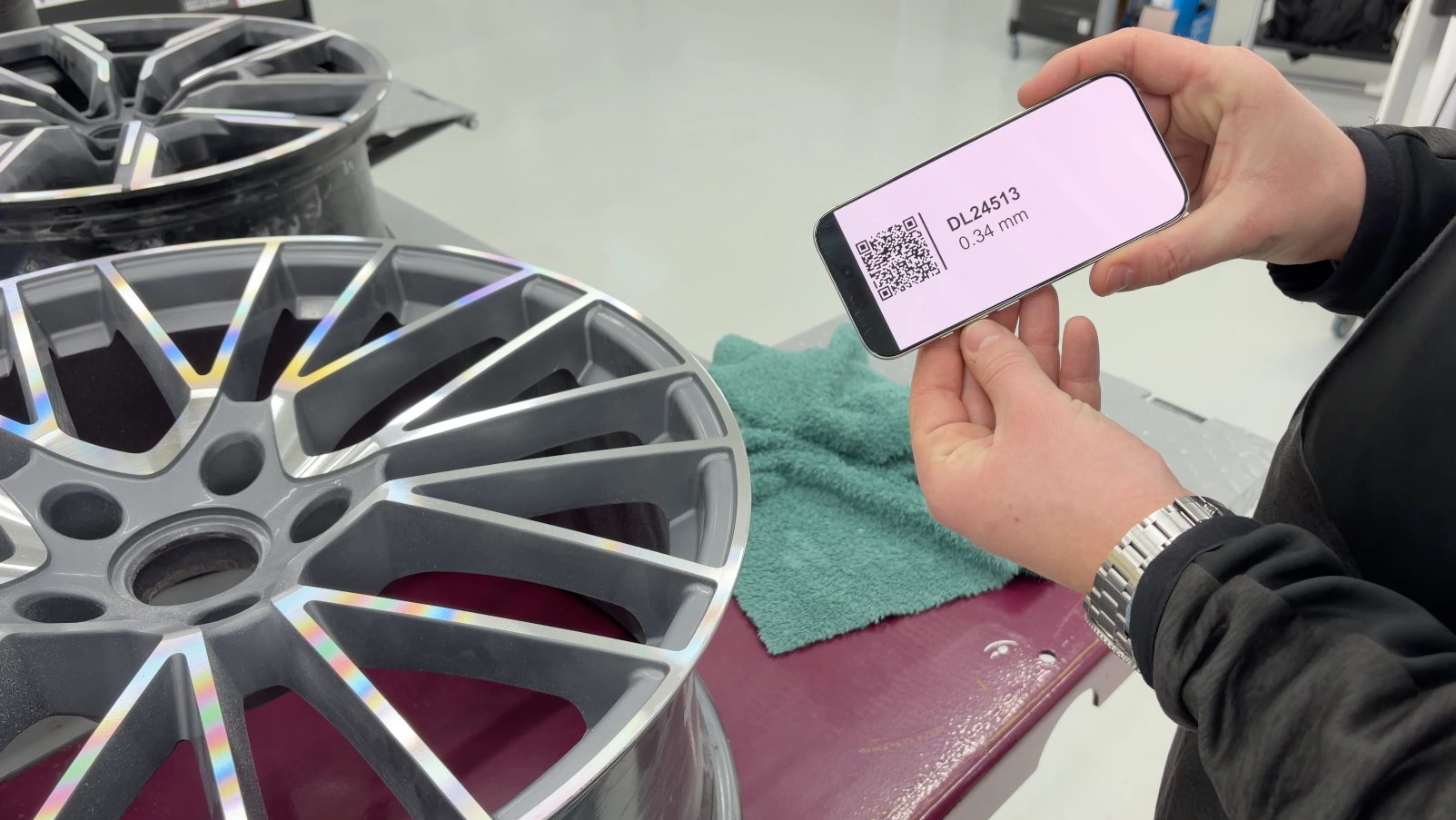 A technician showing repair documentation of a diamond cut wheel after it has been repaired on the WR-DCM3 Diamond Cut Machine