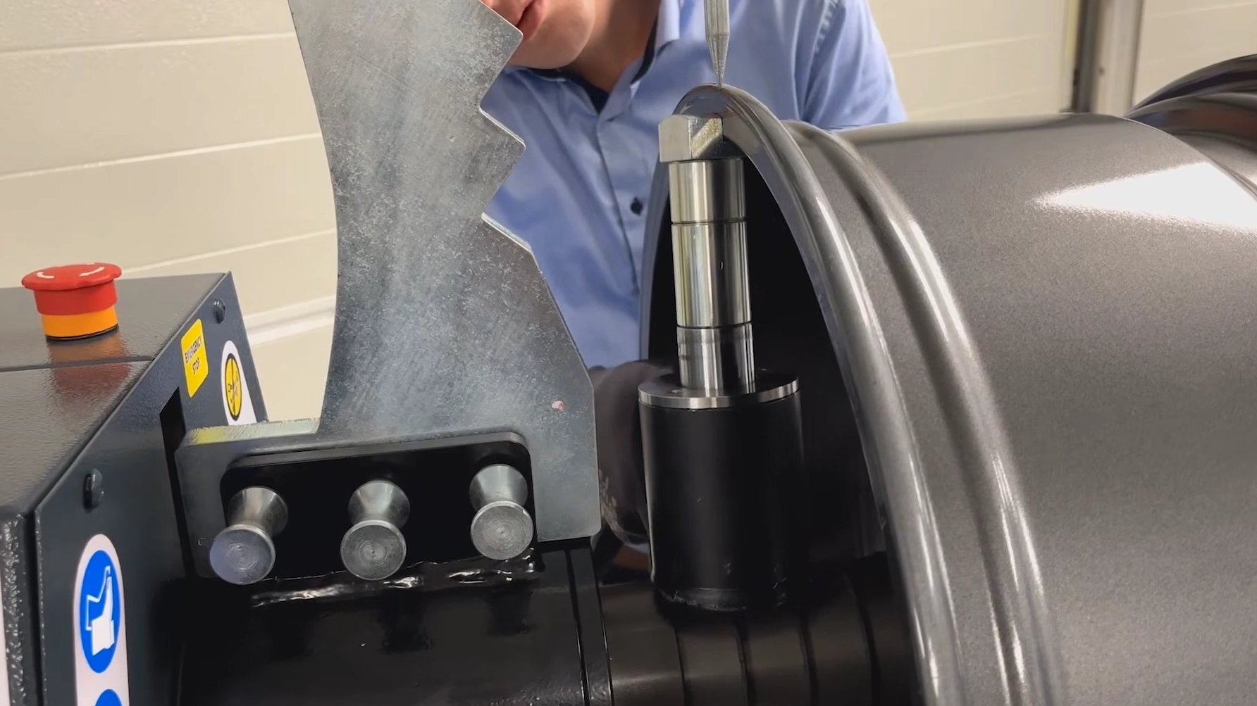 A technician inspecting the wheel straightening process using the WM350 Electro-Hydraulic Wheel Straightener